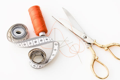 sewcial evening - adult sewing club - photo of tape measure, thread and scissors on white table.