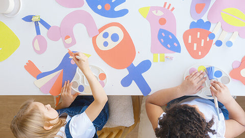 little crafters club - toddlers painting on a table covered with lots of patterns