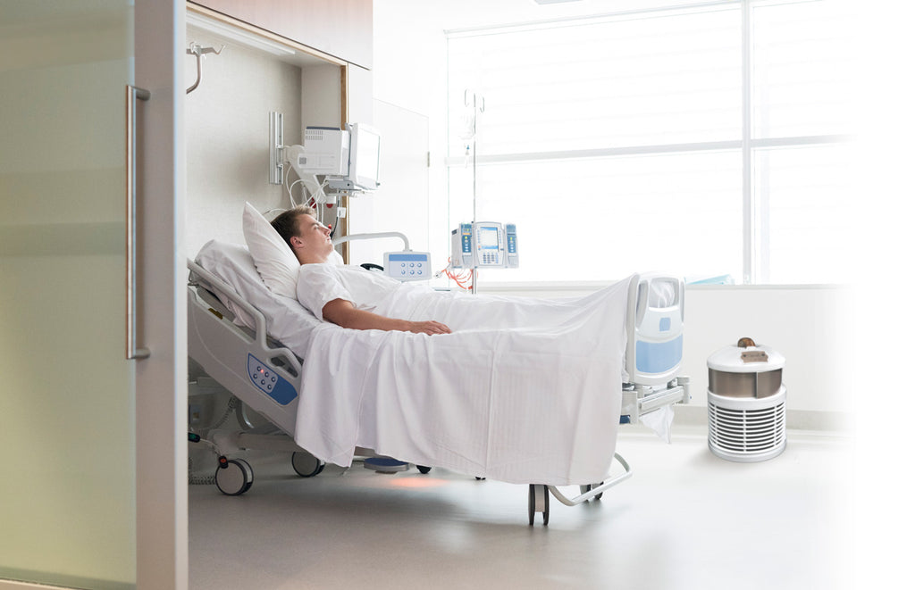 man in hospital bed with defender air purifier