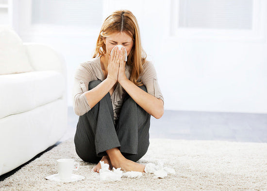 woman blowing her nose from allergies