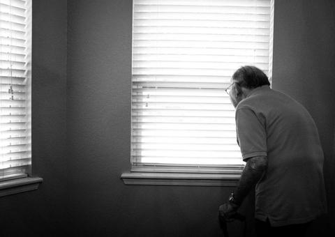 elderly man looking out the window
