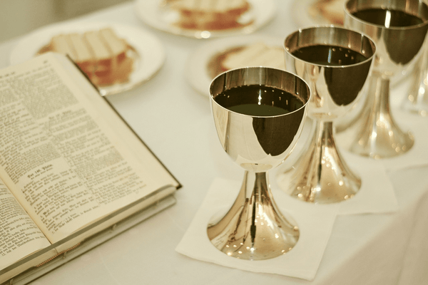 Tisch mit Bibel, Messwein und Brot