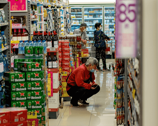 Mann vor dem Weinregal im Supermarkt