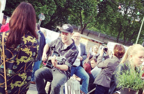 Mann spielt Gitarre und singt auf dem Weine vor Glueck Festival 