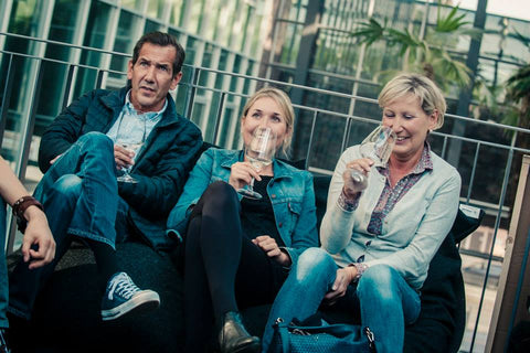 Gäste auf Sofa beim Weine vor Freude Festival probieren Wein 