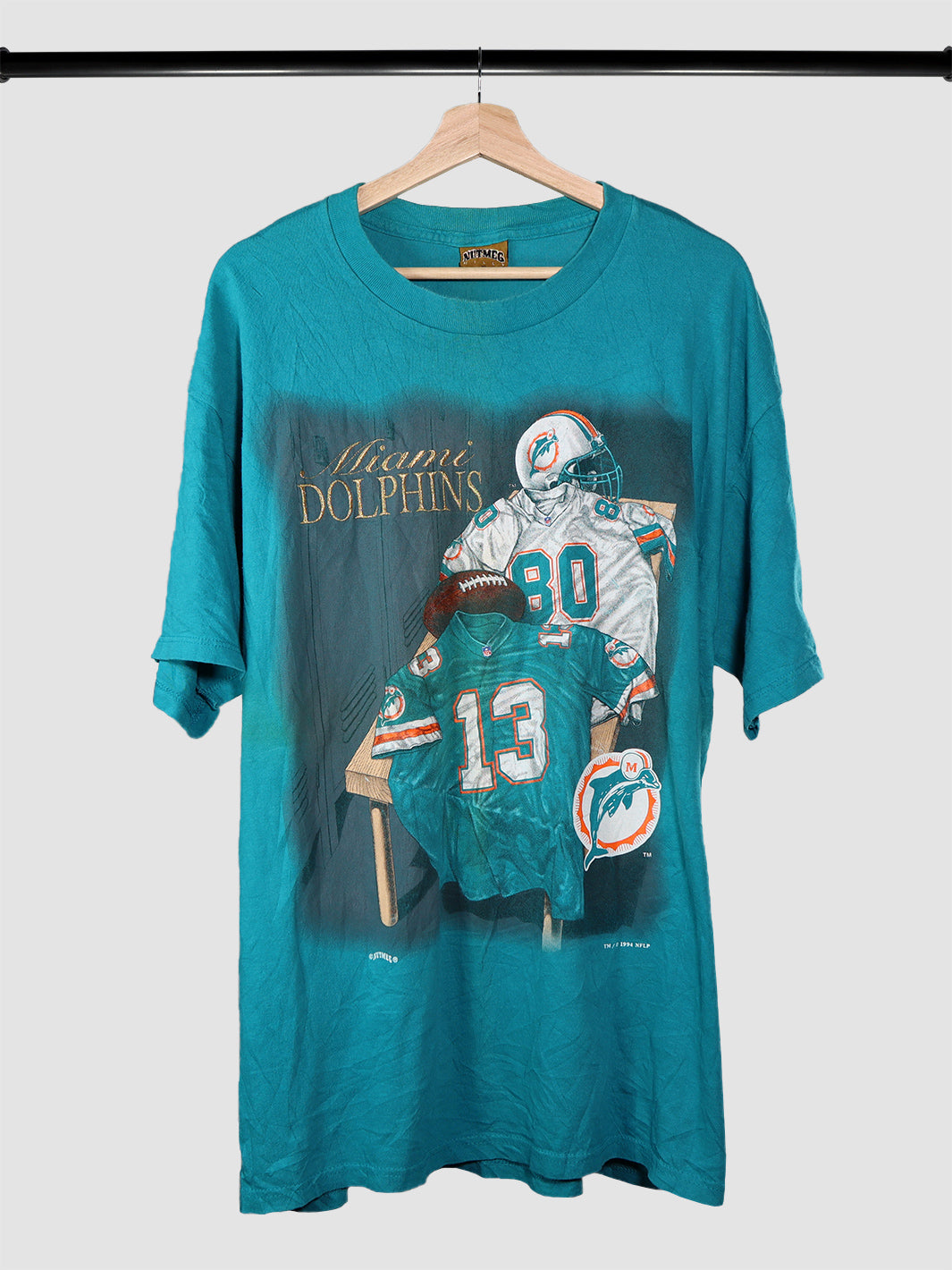 Vintage 1994 Miami Dolphins tshirt hanging on a rack.
