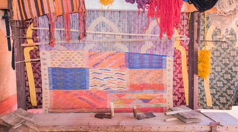 A photo of a colorful handmade Moroccan rug being made in a loom
