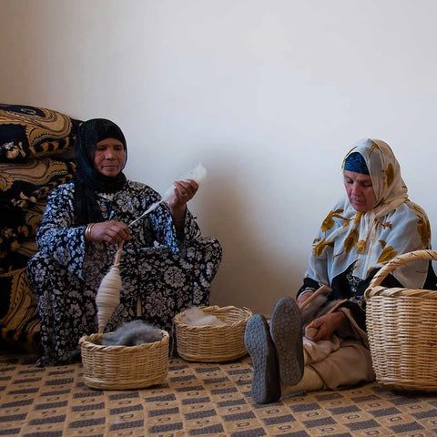 Berber artisans weaving a handmade Moroccan rug