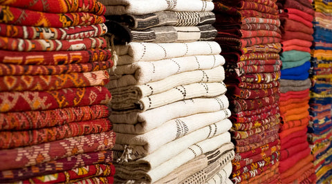 Stock of handmade Moroccan rugs arranged one on top of the other