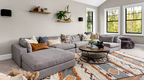 beautiful living room interior with colorful area rug large couch and abundant natural light