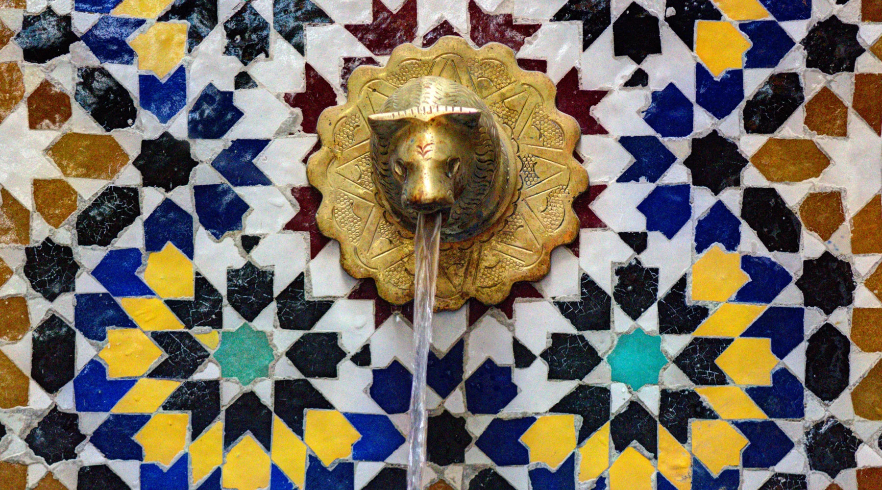 moroccan zellige on fountain with traditional brass tap