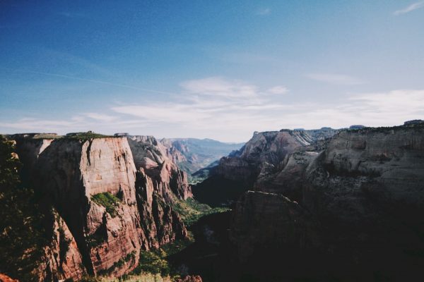 Panoramic view of Zion with red rocks and lush, green valley. 