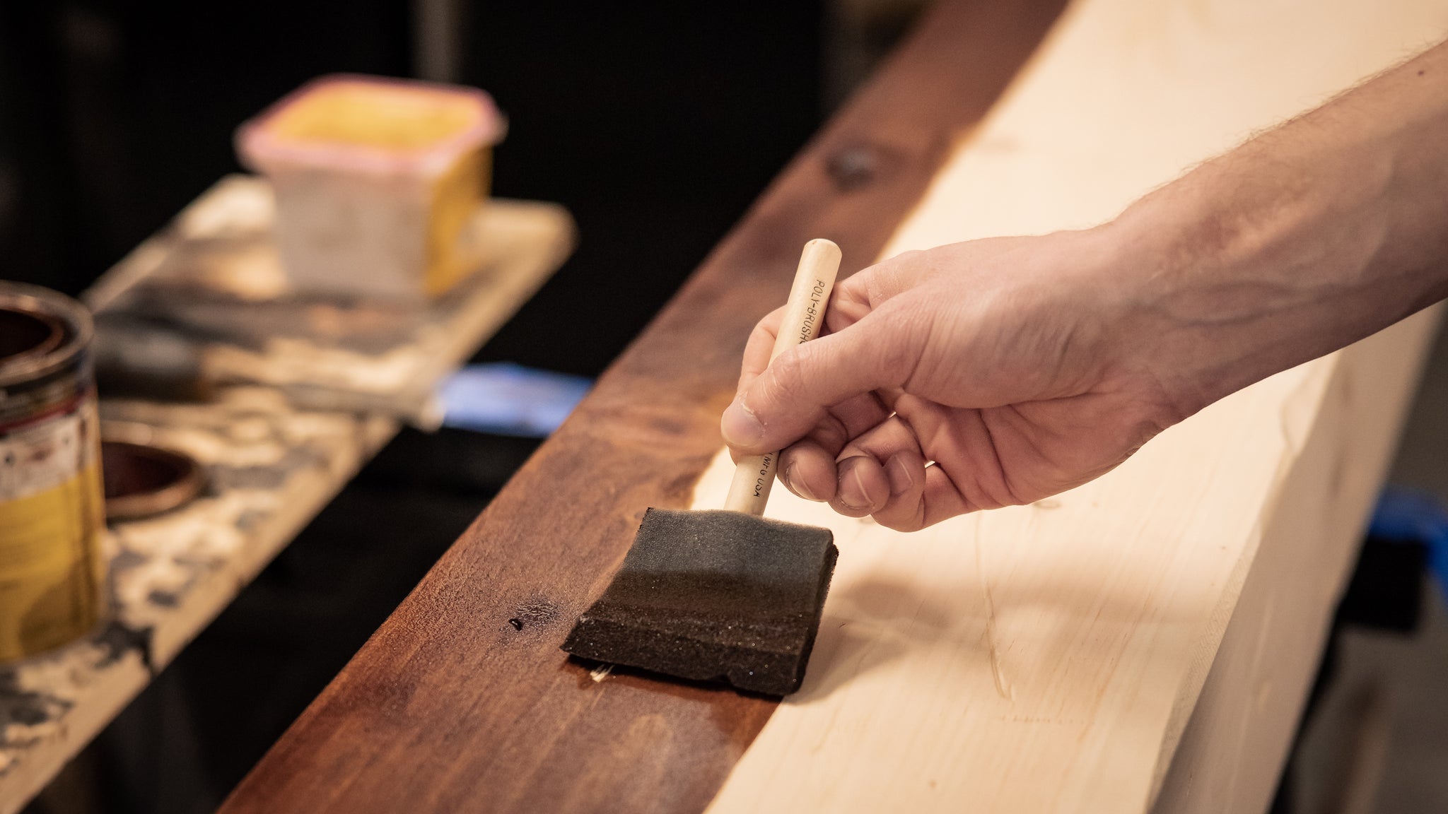 Wood mantel being color stained by hand.