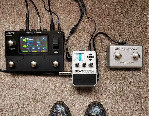 A picture from Instagram of the Aeros Loop Studio, BeatBuddy and Footswitch+ connected together on the floor, with someone's shoes visible near the bottom of the image.