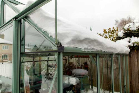 Rhino Greenhouse with thick layer of snow on the roof, falling in the gutter.