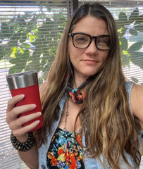 Picture of Fifty Skies owner, Janessa Bookout with her reusable coffee mug