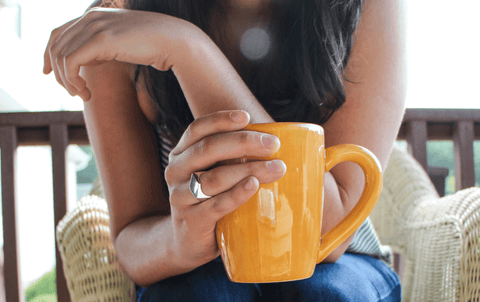 woman holding orange coffee cup