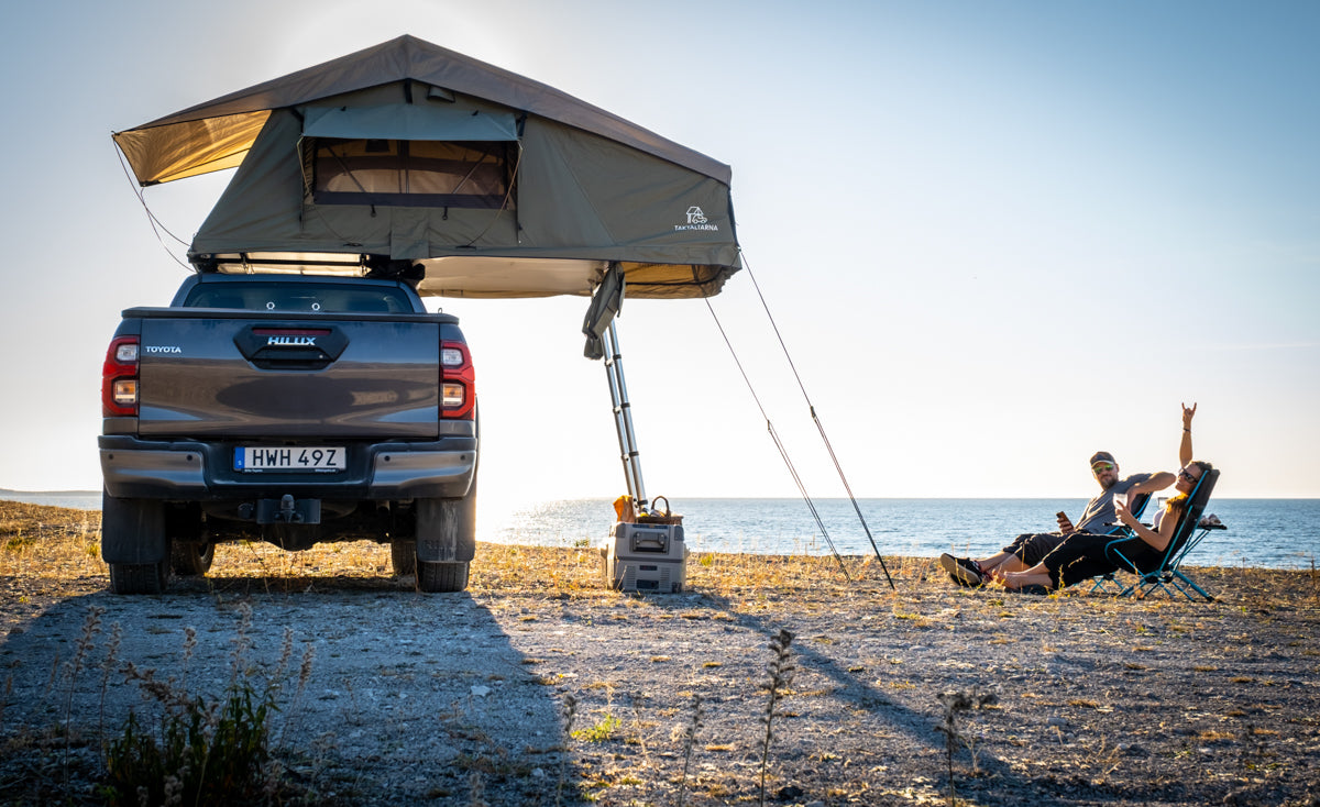 Taktält på bil på en strand på Gotland med människor som sitter i solstolar