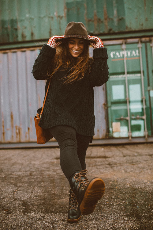 Influencer wearing black sweater, jeans and holding black hat walking outside wearing Cougar Original Pillow Boot in Black