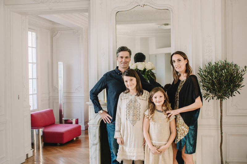 Sara Bancroft walking with family standing at inside a house