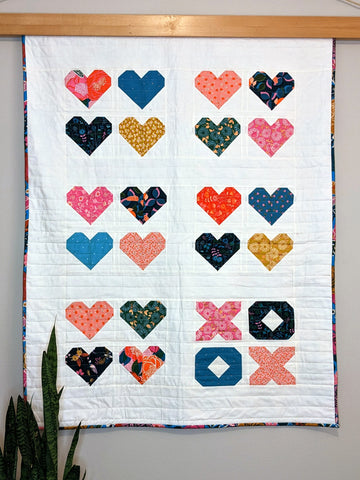 Pink, blue, yellow heart quilt on white background