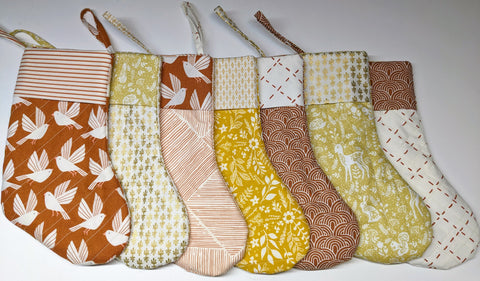 7 yellow and orange quilted Christmas stockings lined up