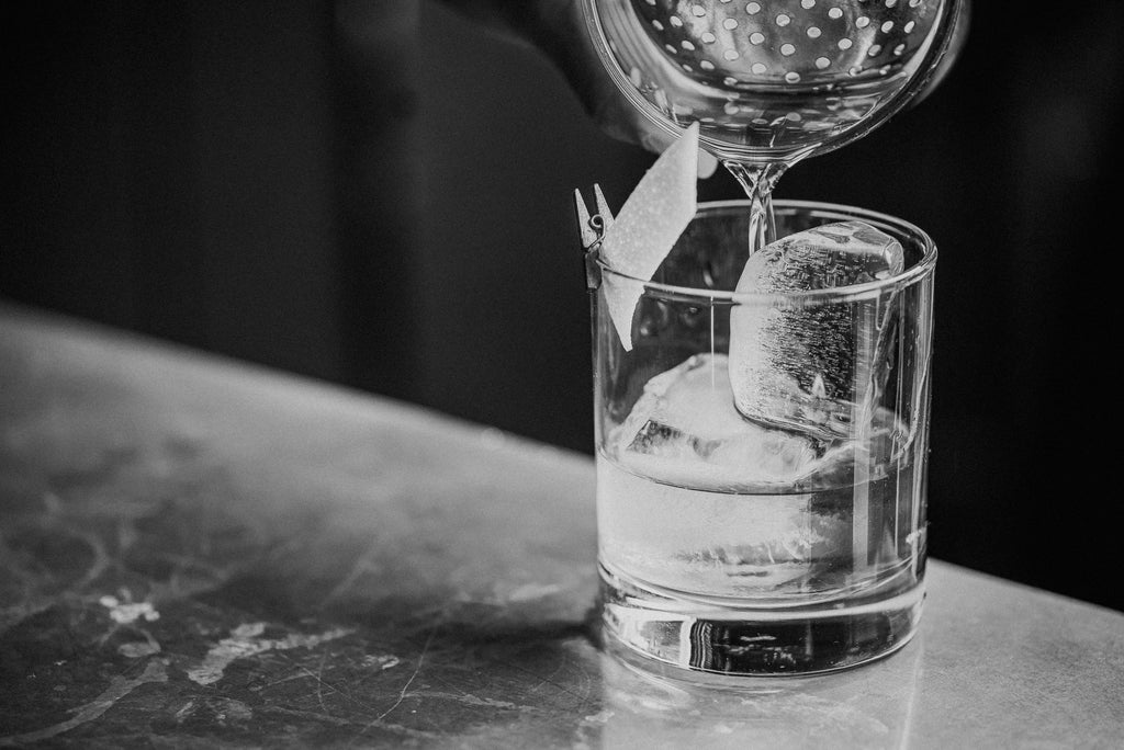 Black and White photo of glass with liquid being poured in