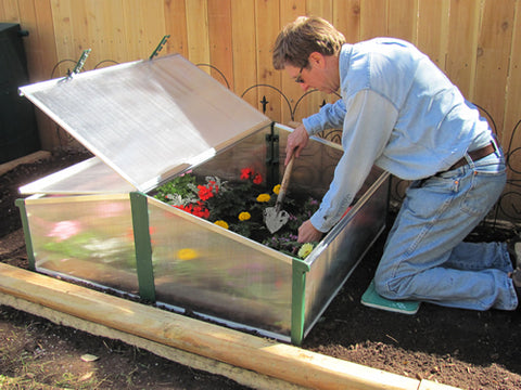 Easy Fix Double Cold Frame Garden, a man is planting flowers and various seeds.