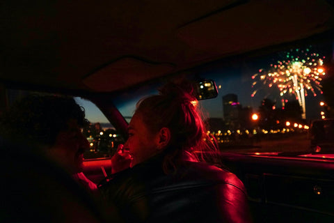 couple assis dans une voiture regardant des feux d artifice