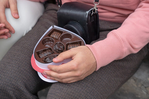 couple avec une boîte de chocolats en forme de cœur