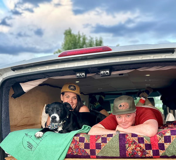 Couple laying in van with their dog