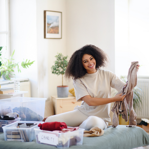 Woman decluttering and sorting through clothes