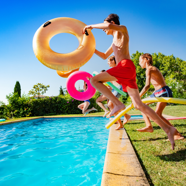 People jumping into pool with summer inflatables