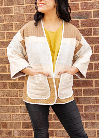 close-up of a girl wearing a 3 quarter length switched jacket with warm tones, cream and browns