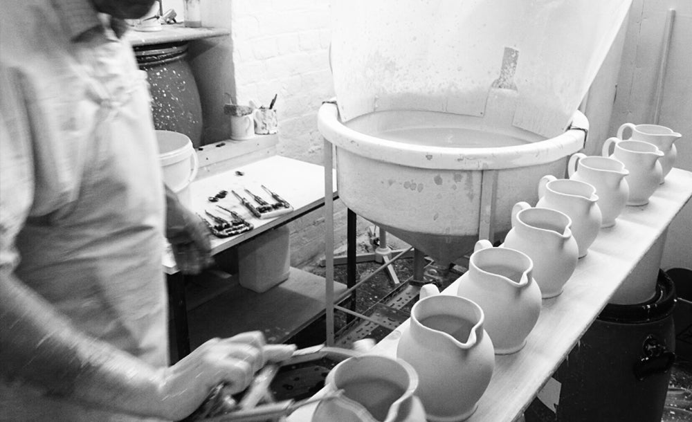 Dipping ceramic jugs into a pool of glaze