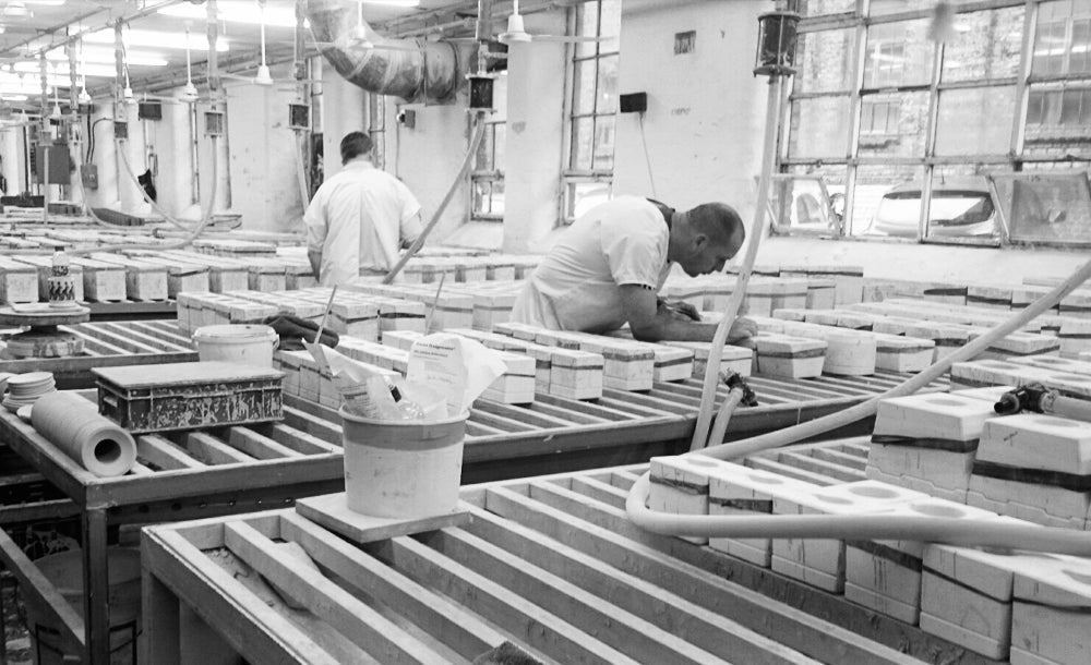 Filling the plaster mug moulds with slip