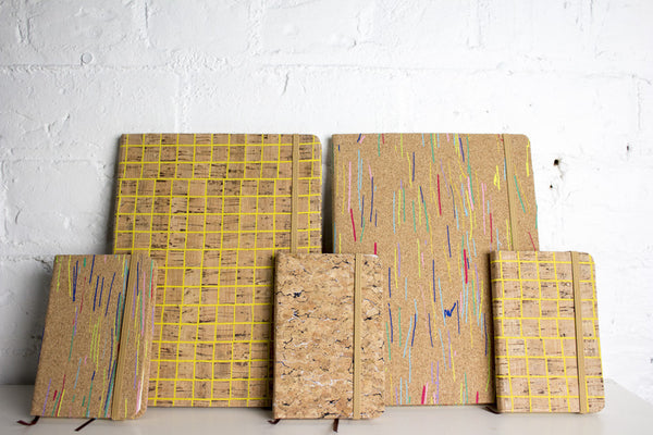 Collection of cork note books in yellow and colour patterns over the cork