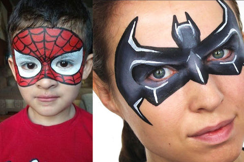 Close-up of two kids, one with a Spiderman face paint design and the other with a Batman face paint design, showcasing the popularity of superhero themes in face painting for kids