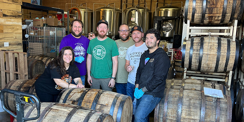 The Midwest Barrel Co. and Whiskey Hill Brewing Co. teams in the brewery's barrel-aging area.