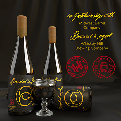 Three bottles of Barreled in Bond with one laying on its side and a small glass with beer in front