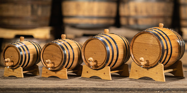 Small oak aging liter barrels of varying sizes on stands