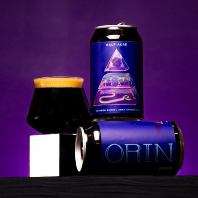 Two beer cans and glass of Orin from Half Acre