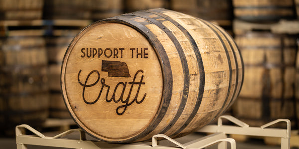 Full size whiskey barrel engraved with Support the Craft and state of Nebraska outline on the barrel head 