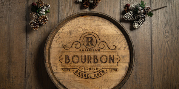 Engraved whiskey barrel head hanging on a wood panel wall with R Bourbon design