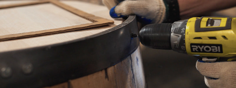 Person using square to make sure design on barrel head is centered.