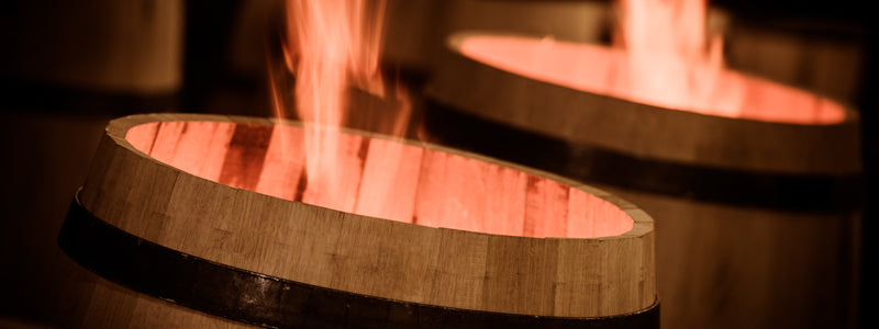 Flame coming out the top of a barrel as it's charred at a cooperage