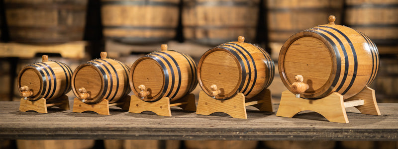 Different sizes of oak aging barrels in warehouse of other barrels