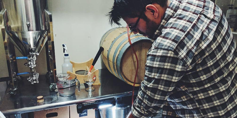 Ricky Cervantes transferring beer from a small barrel