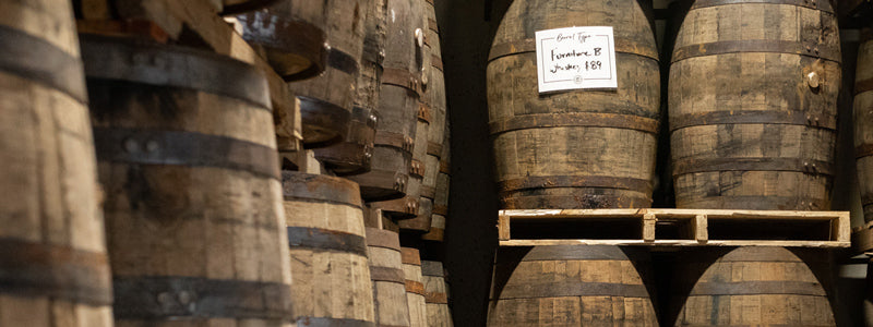 Furniture grade whiskey barrels on pallets in a warehouse