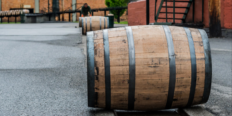Whiskey barrels rolling on a track outside a rickhouse at a distillery